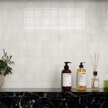 Close-up of Bianco Dolomite polished square marble mosaic in a shower niche
