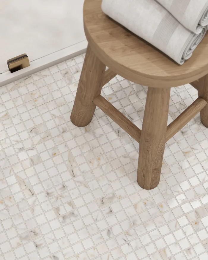 Close-up of Calacatta Gold honed marble mosaic on a bathroom floor showing veining detail